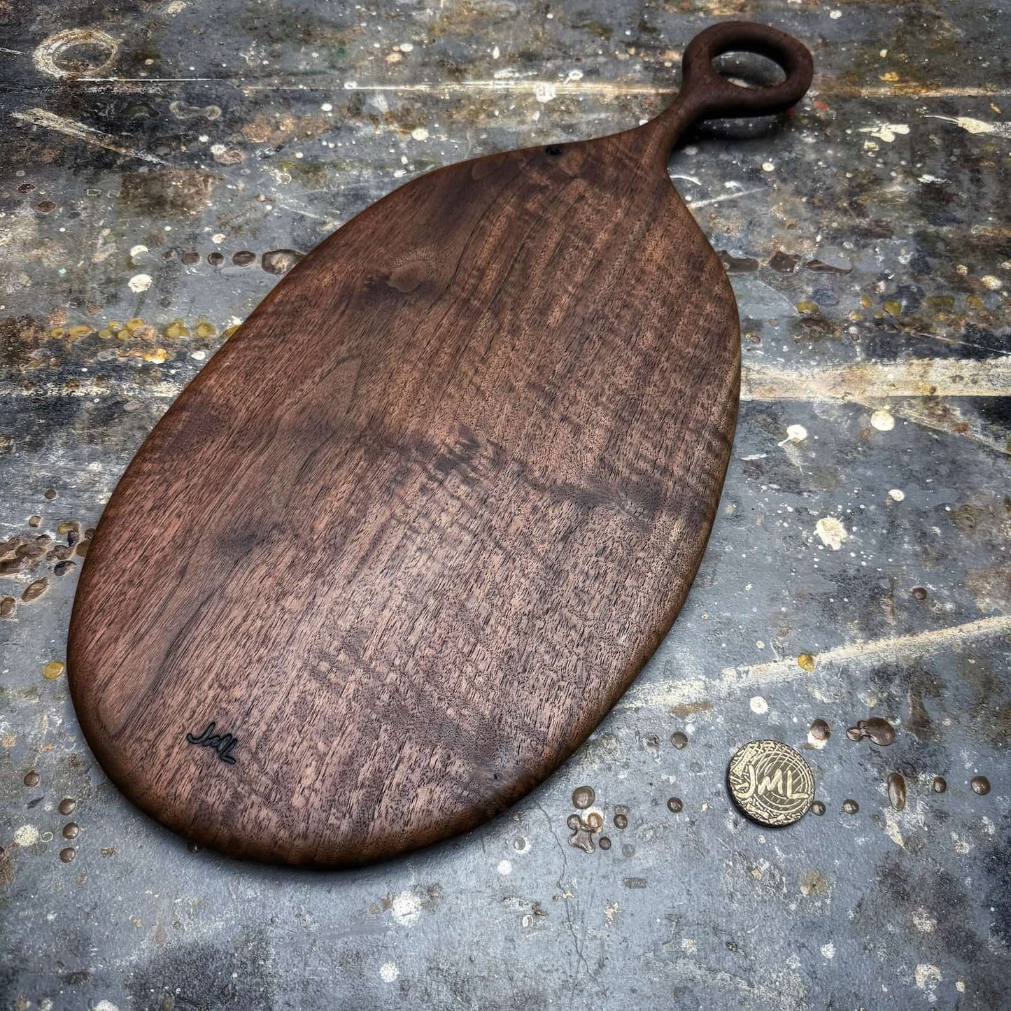 dark walnut serving board photographed on workshop surface