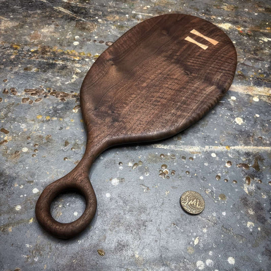 angled view of dark walnut serving board with rounded profile