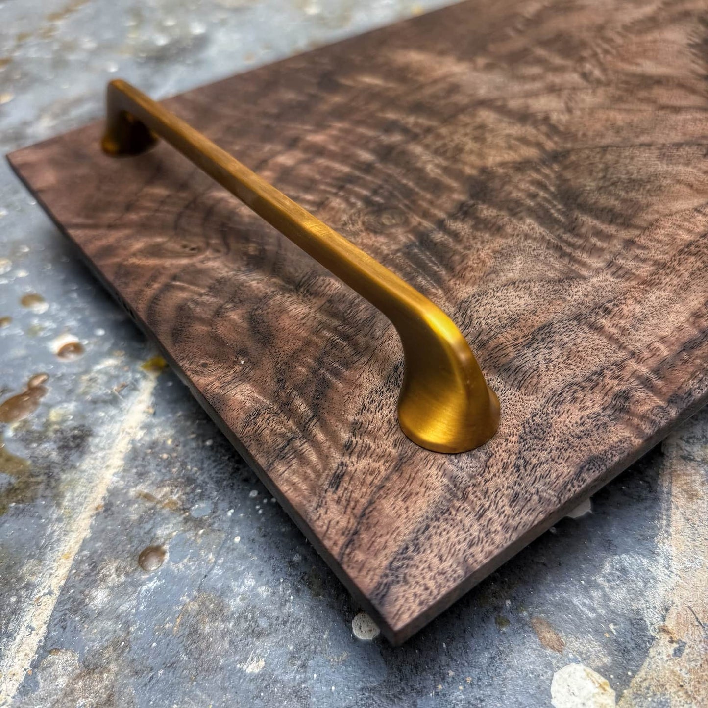 closeup of brushed gold handle and walnut grain