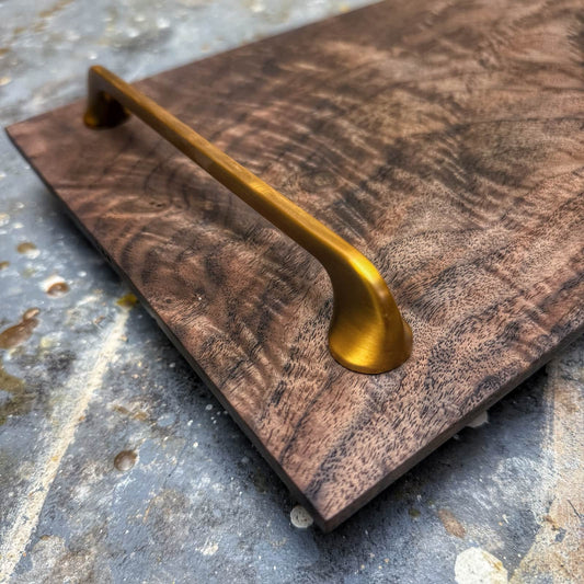closeup of brushed gold handle and walnut grain
