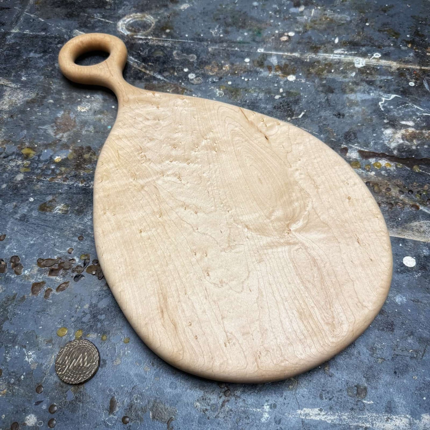 overhead view of birdseye maple board with round handle