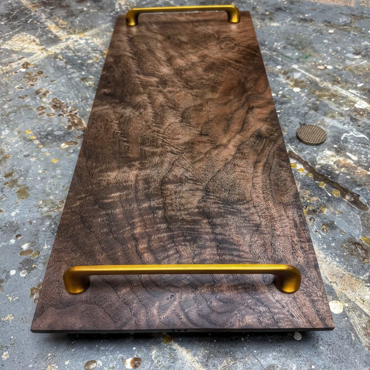 overhead view of curly walnut tray with gold handles