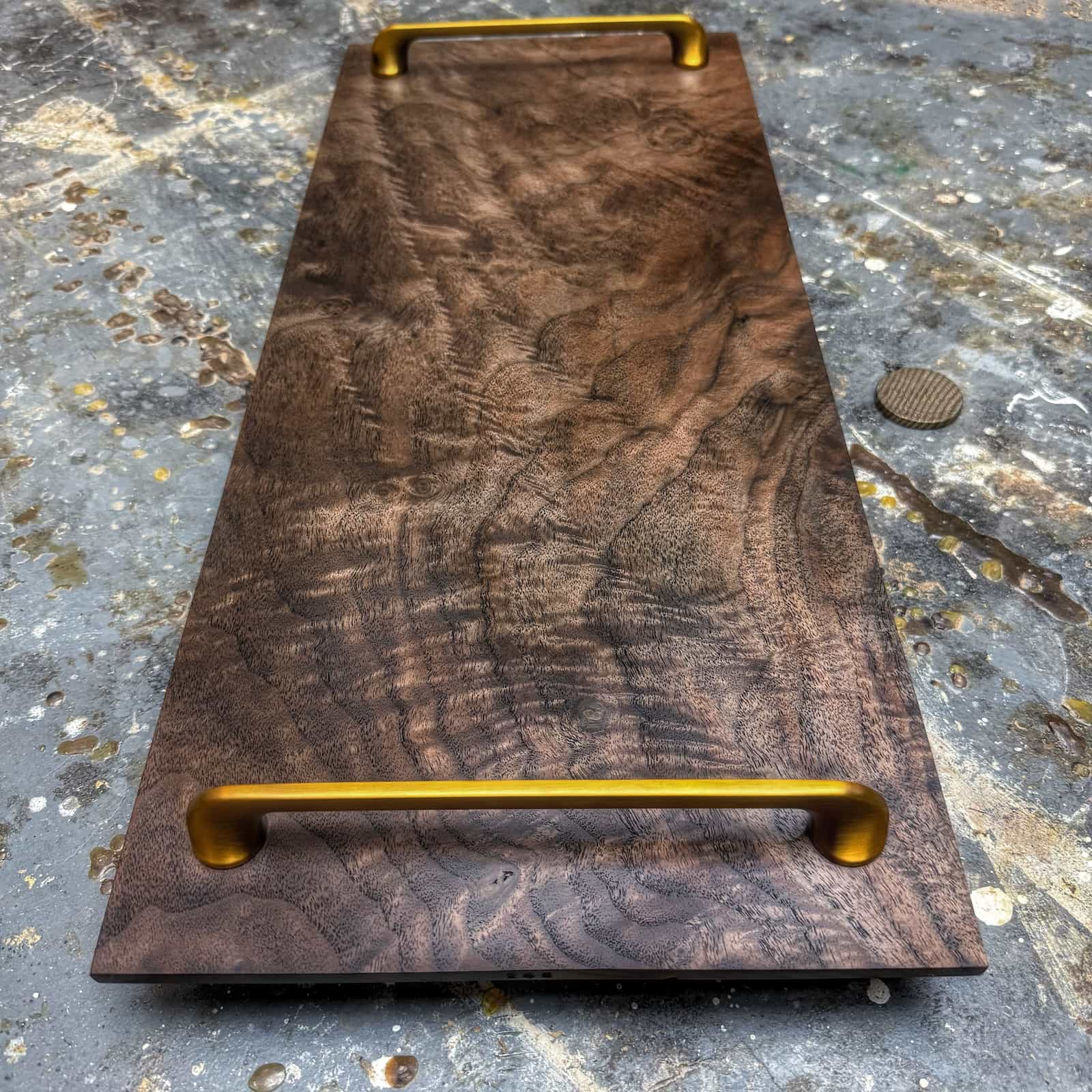 overhead view of curly walnut tray with gold handles