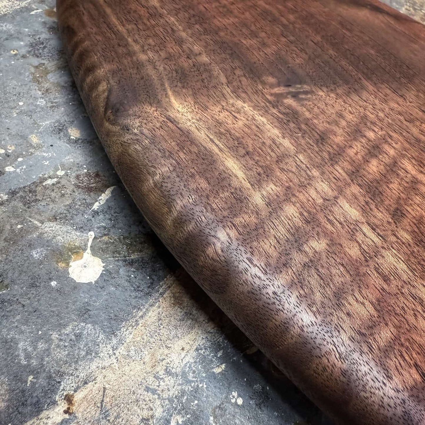 detail of deep dark walnut surface with subtle curly figure