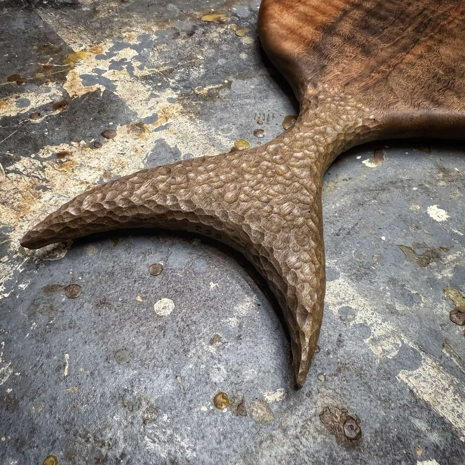 detail of hand carved texture on walnut fish tail handle
