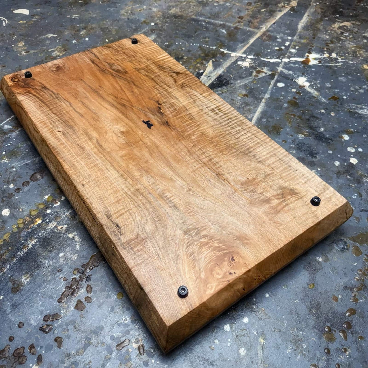 Underside view of handcrafted curly maple tray with JML branding