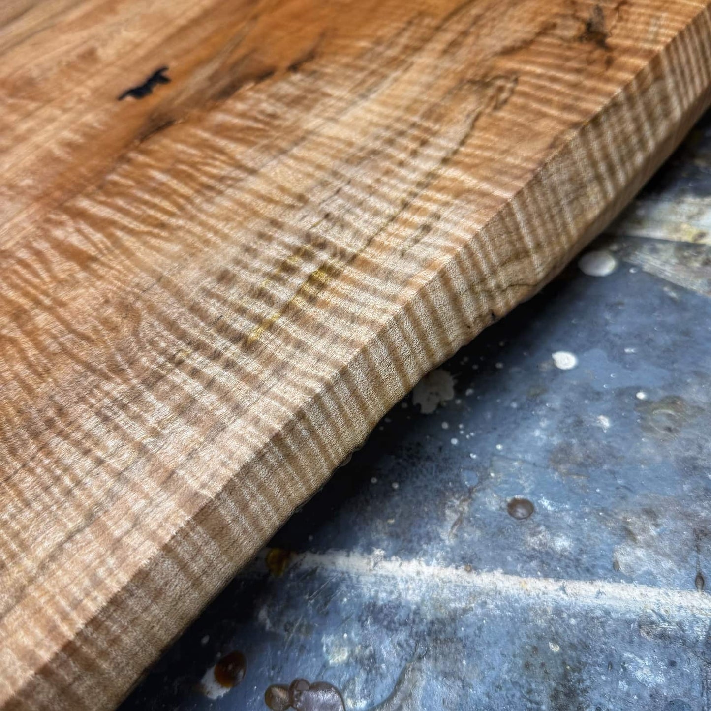 Angled view of curly maple gold handle tray emphasizing depth and grain
