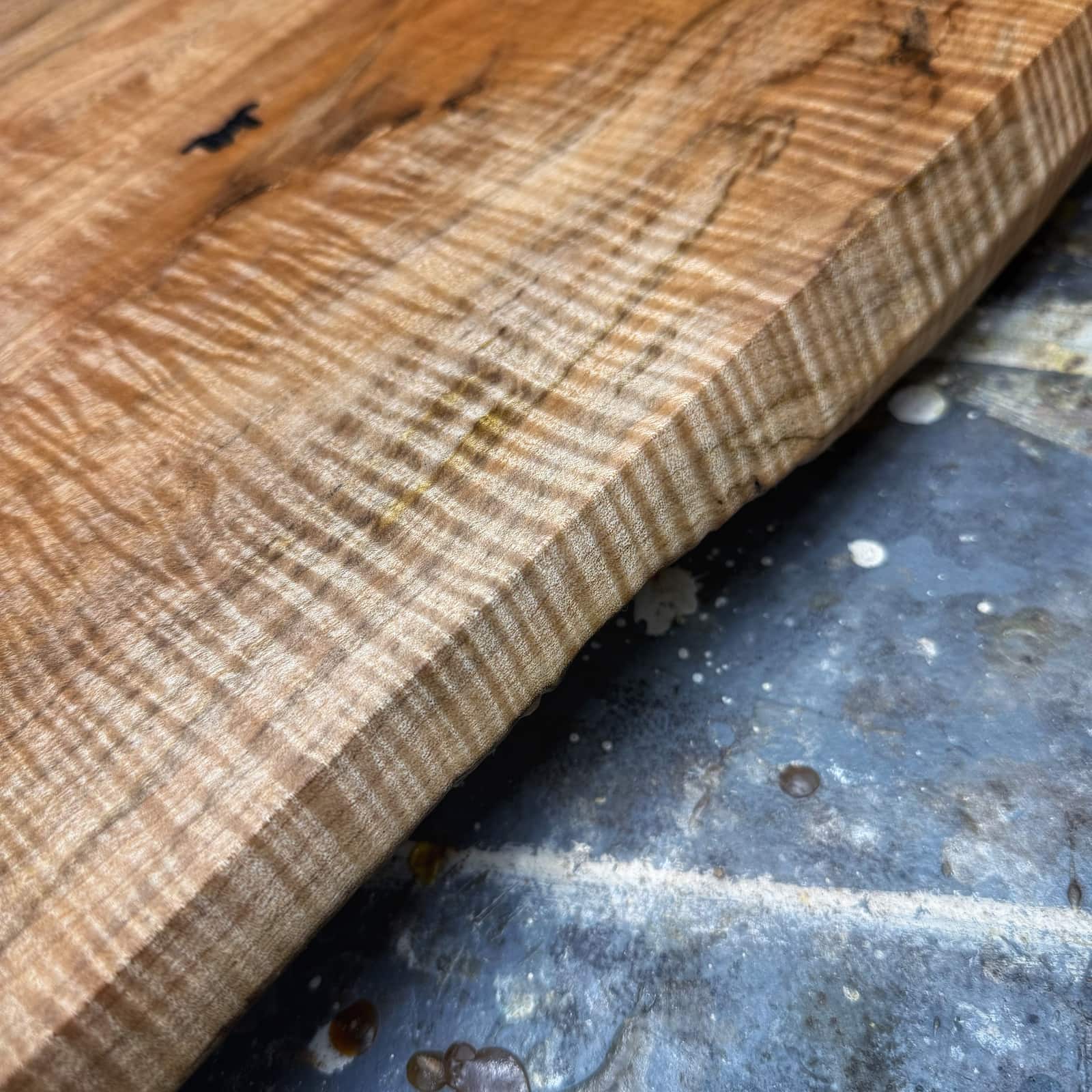 Angled view of curly maple gold handle tray emphasizing depth and grain