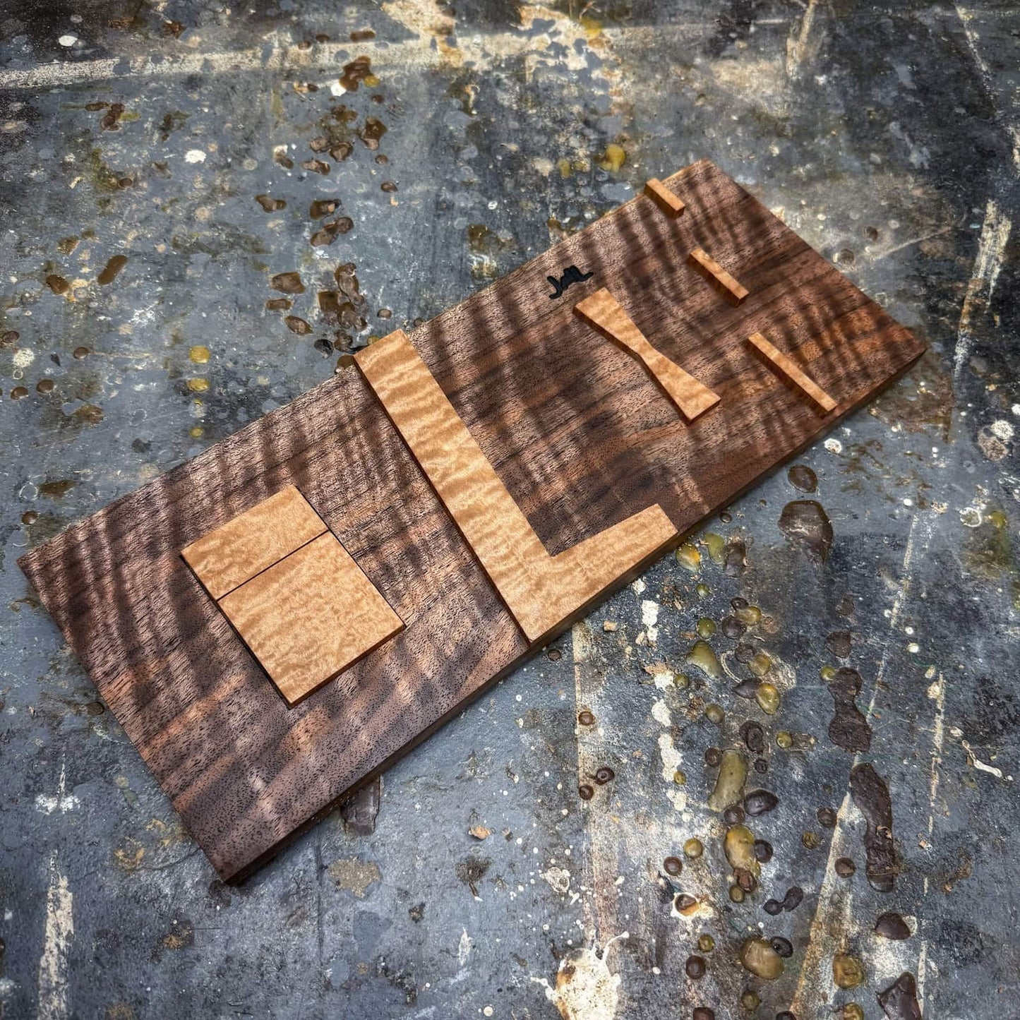 Quilted maple inlay jig parts on curly walnut base