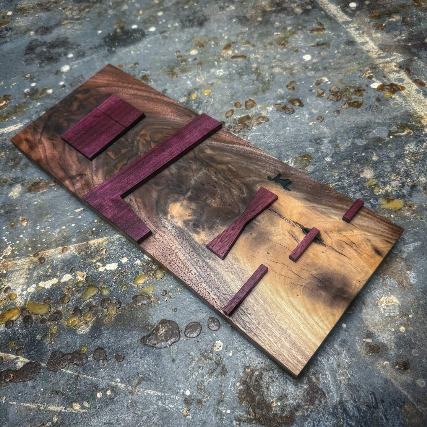 Figured walnut inlay jig with Purpleheart bow tie and straight inlay components on shop floor