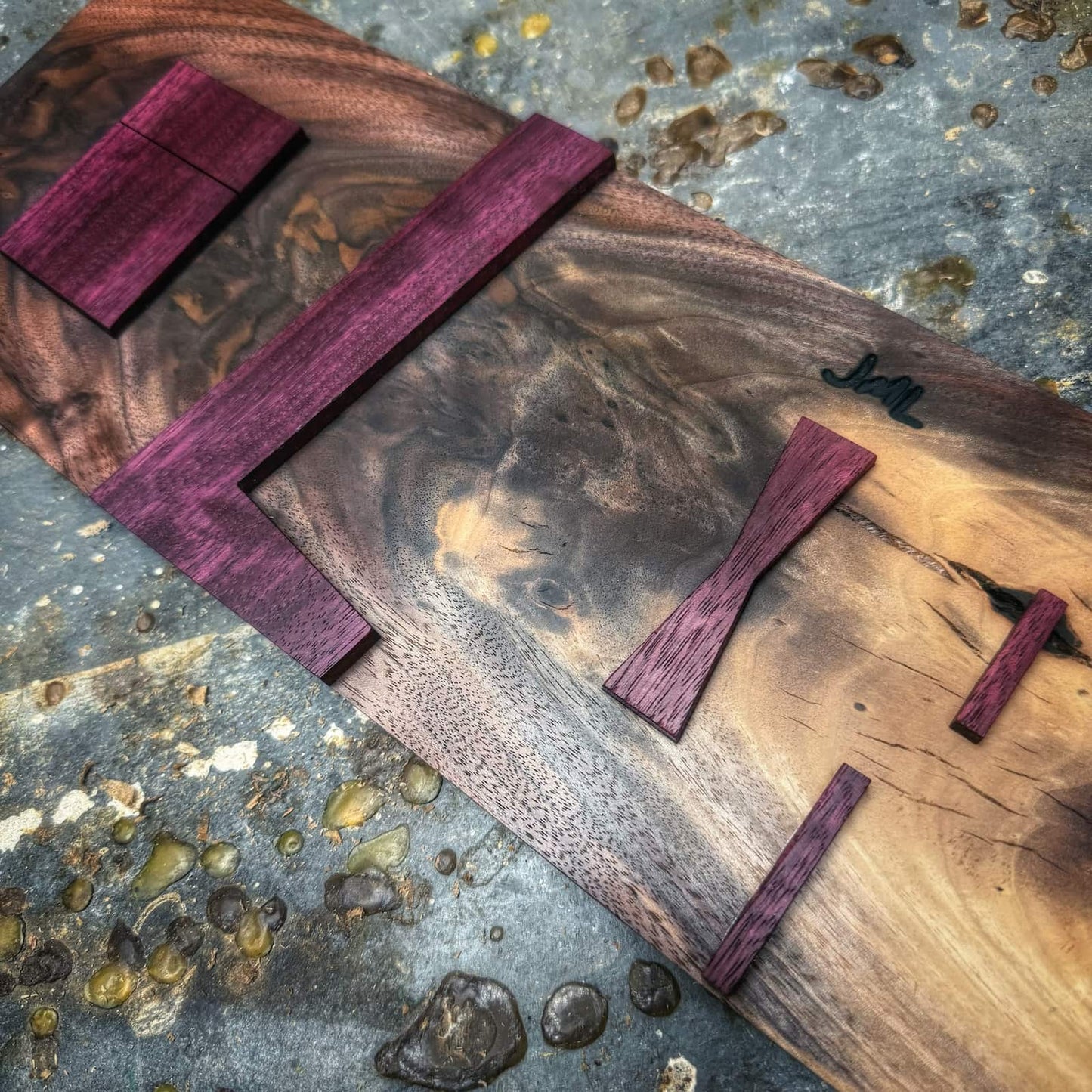 Close-up of Purpleheart straight inlay parts mounted on walnut inlay jig