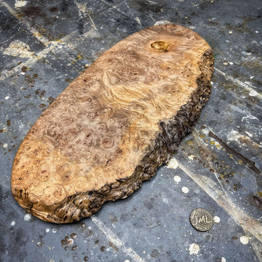 oval maple burl serving board with live edge ridge on workshop surface