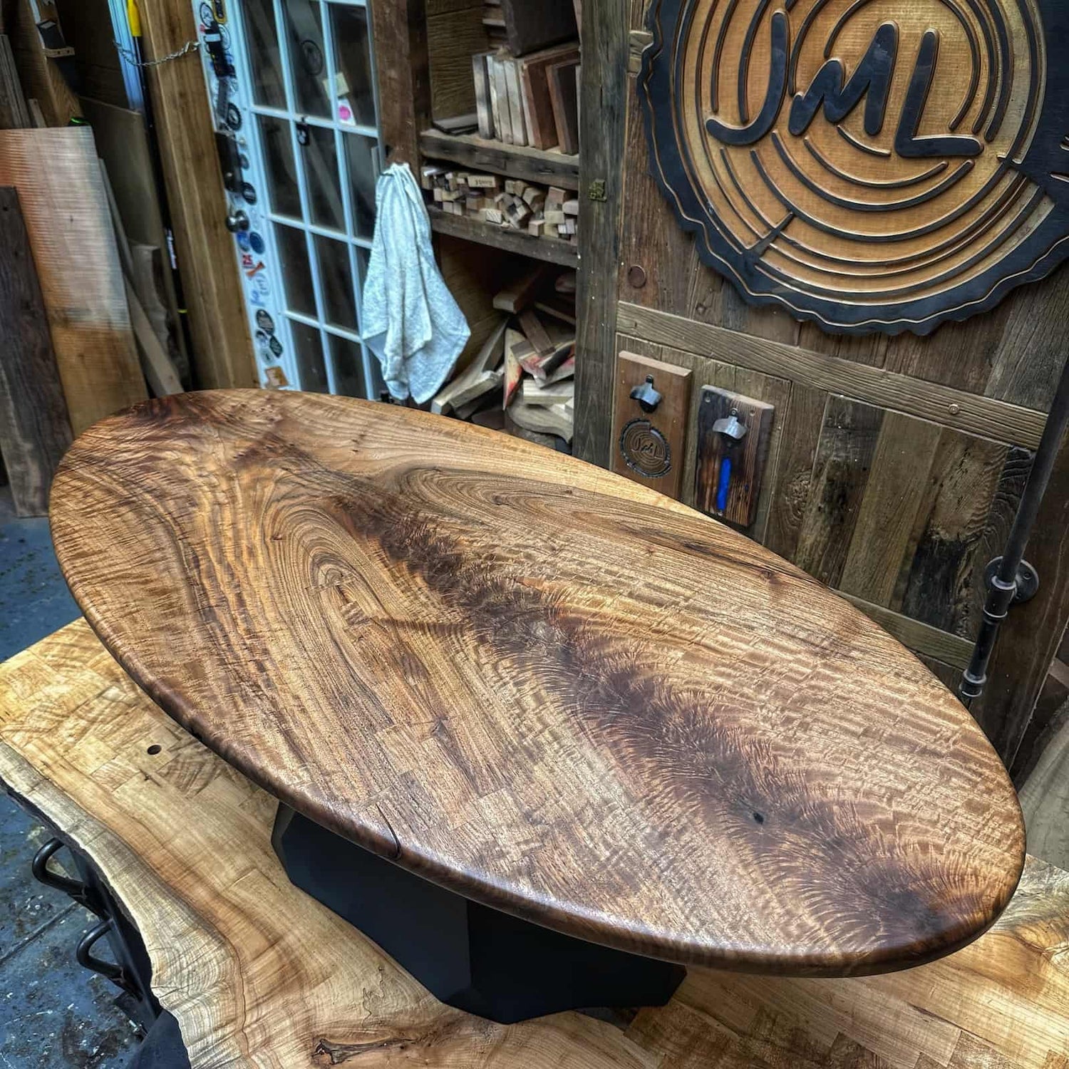 hand built hardwood coffee table with an oval form, deep natural color, and clean modern shaping crafted by JML Woodcraft