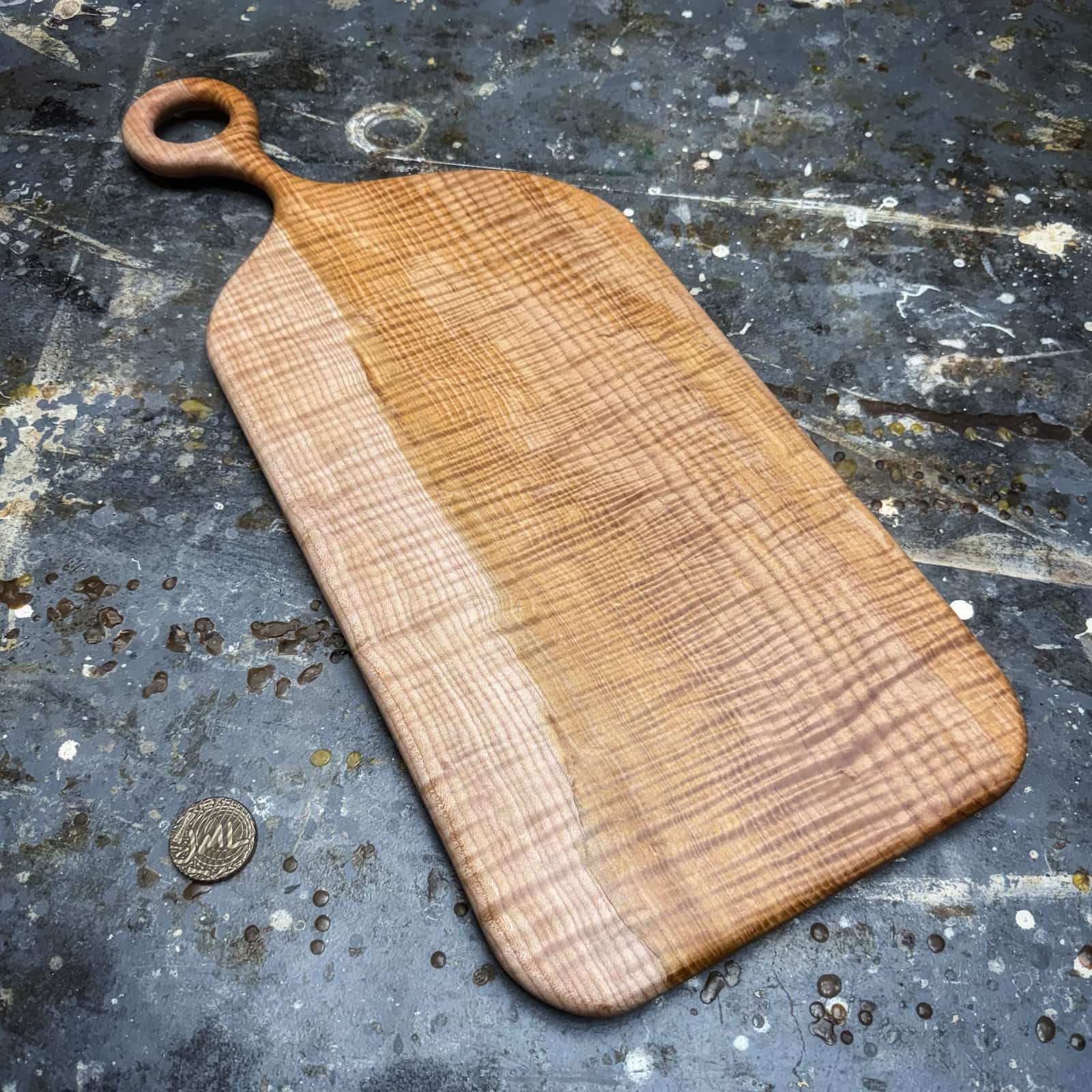 angled view showing sculpted round handle and flowing grain